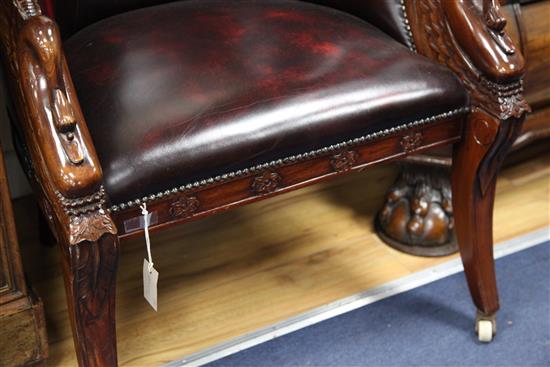 A pair of French Empire style carved mahogany and brass studded leather tub shaped armchairs,